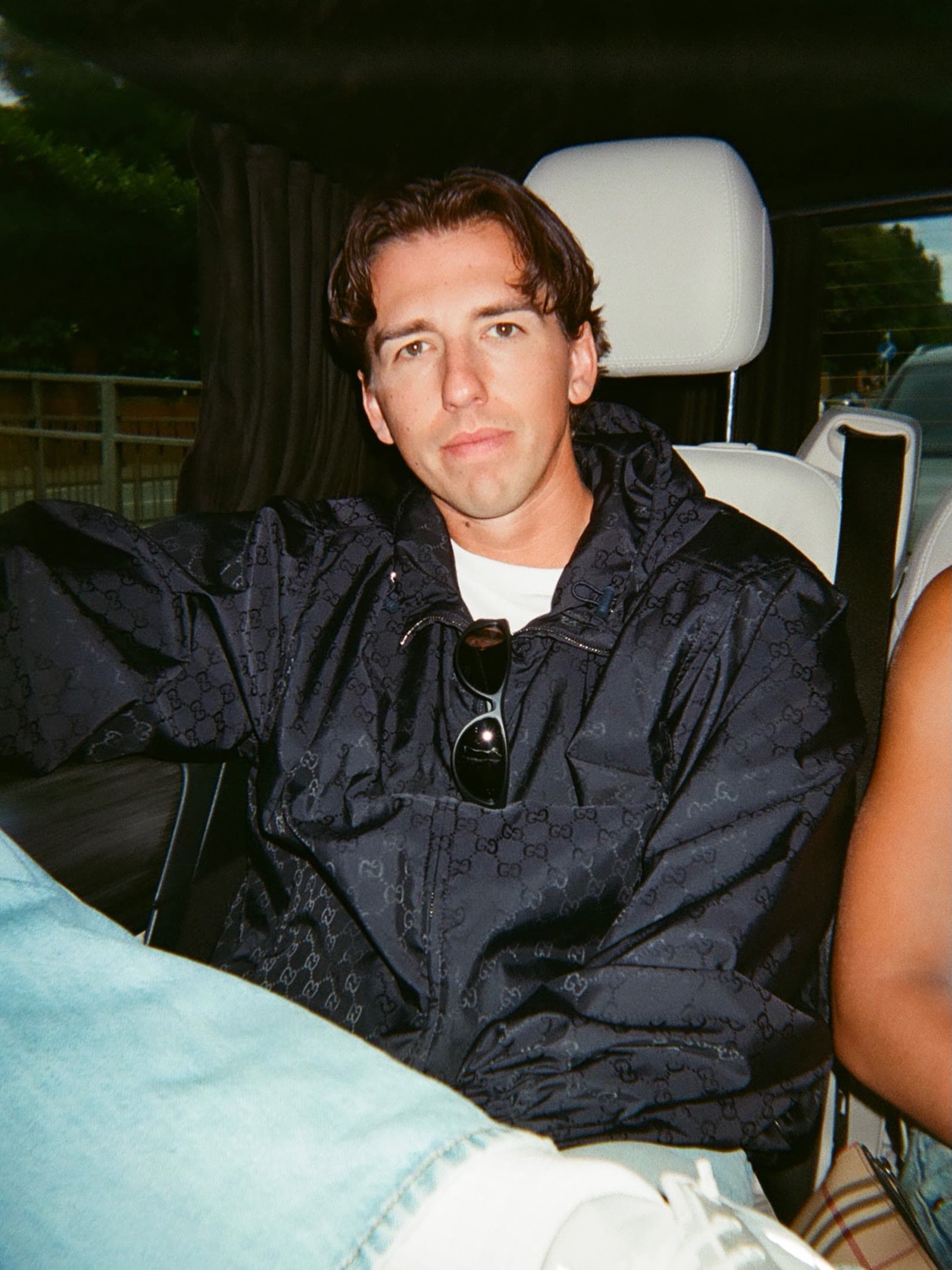 Josh Baker in the back of a car, looking into the camera